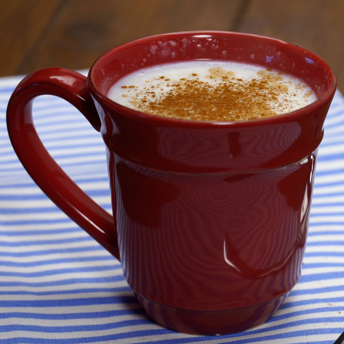 Mingau de tapioca finalizado em xícara com canela em pó por cima.