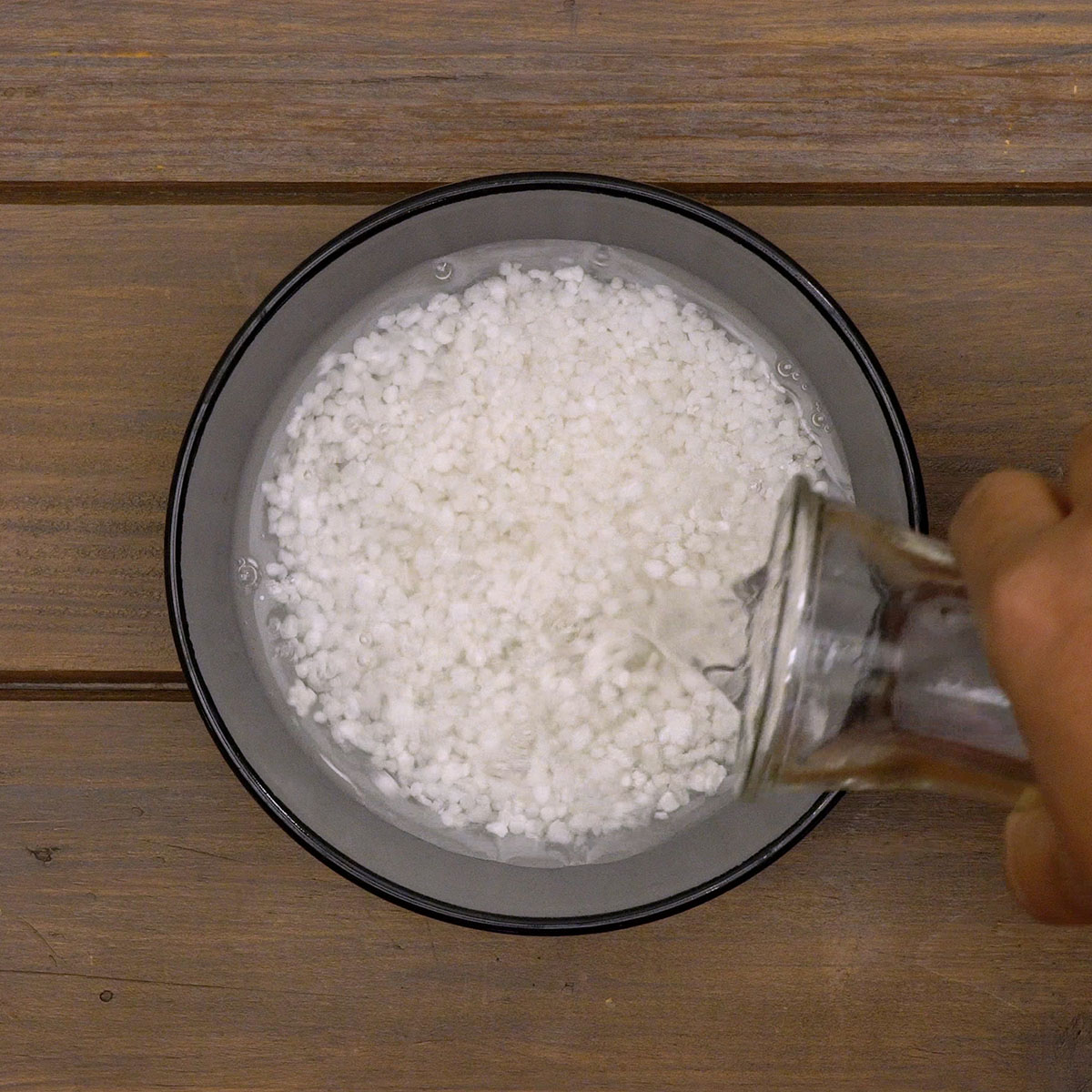 Tapioca hidratando em uma tigela com água para o mingau tradicional.