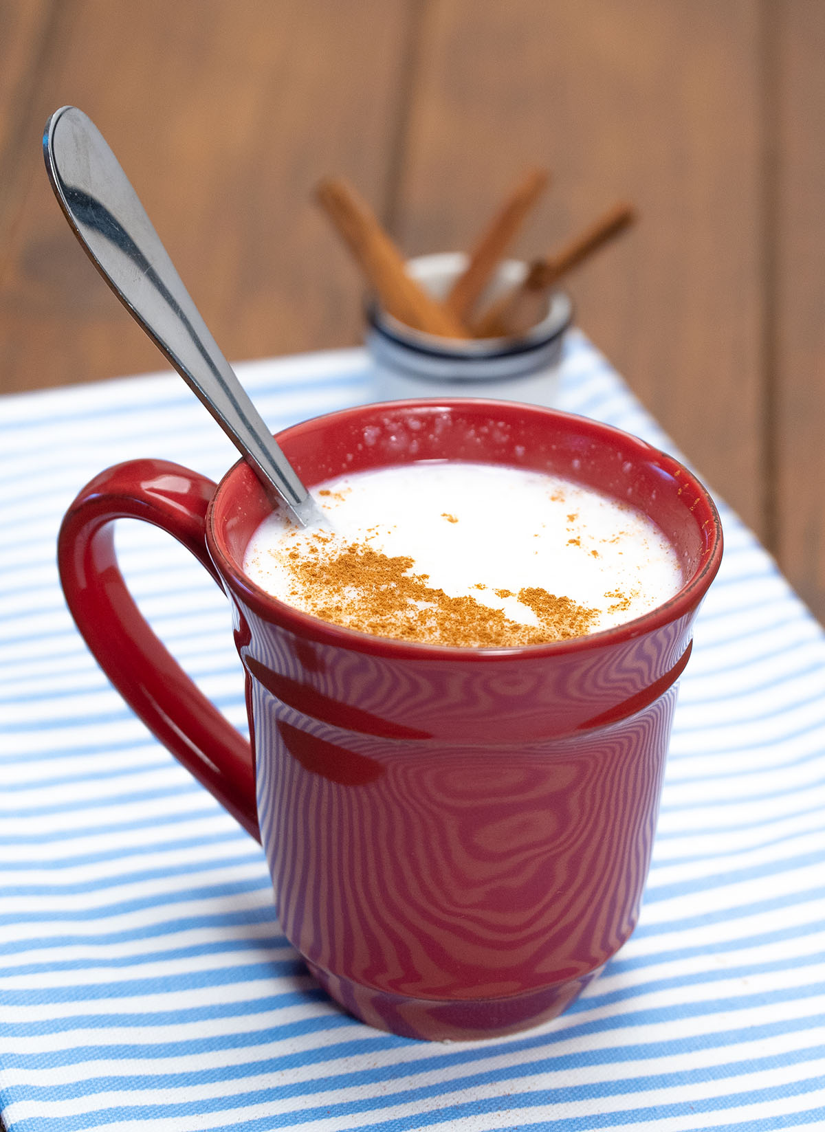 Mingau de tapioca servido na xícara finalizado com canela em pó.