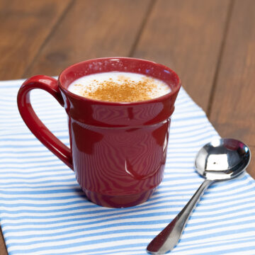 Mingau de tapioca servido na xícara finalizado com canela em pó.