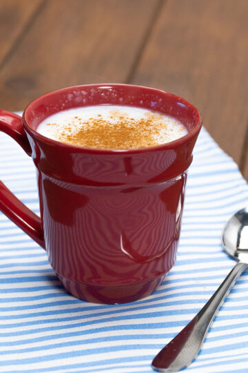 Mingau de tapioca servido na xícara finalizado com canela em pó.