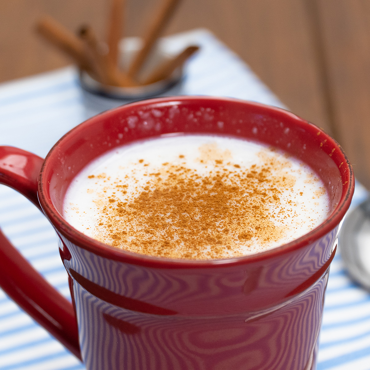 Mingau de tapioca servido na xícara finalizado com canela em pó.