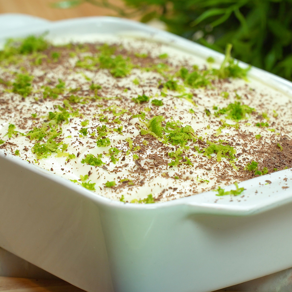 Pavê de limão pronto para servir finalizado com raspas de limão e chocolate.