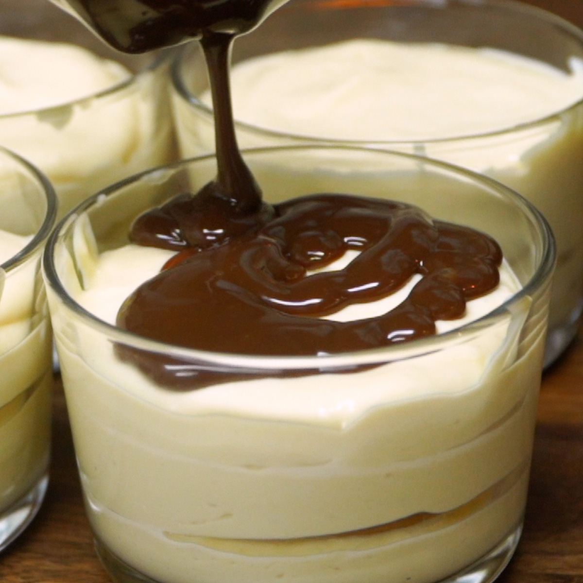 Ganache de chocolate cobrindo o pavê de maracujá no copinho.