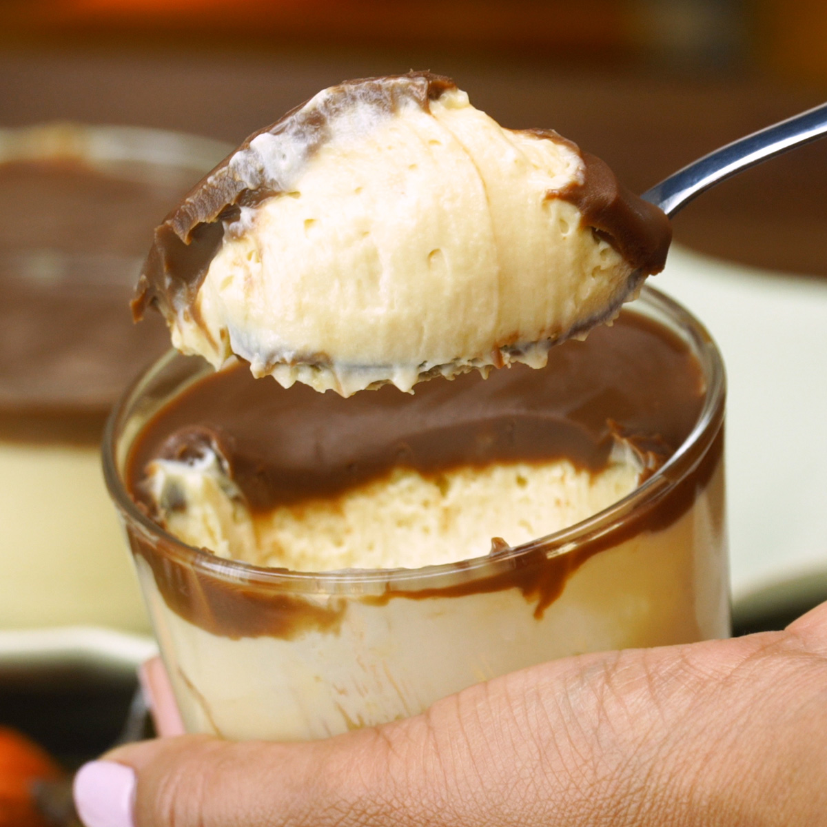 Pavê de maracujá no copinho com ganache de chocolate gelado sendo provado.
