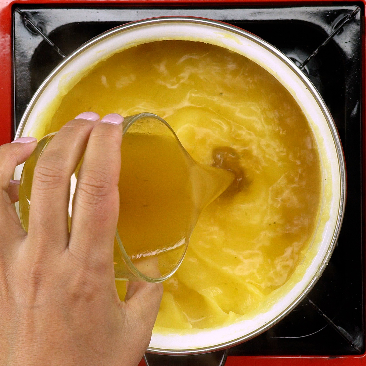 Polenta cremosa engrossando durante o cozimento.