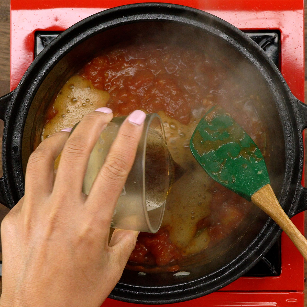 Molho de tomate com cerveja preta cozinhando na panela.
