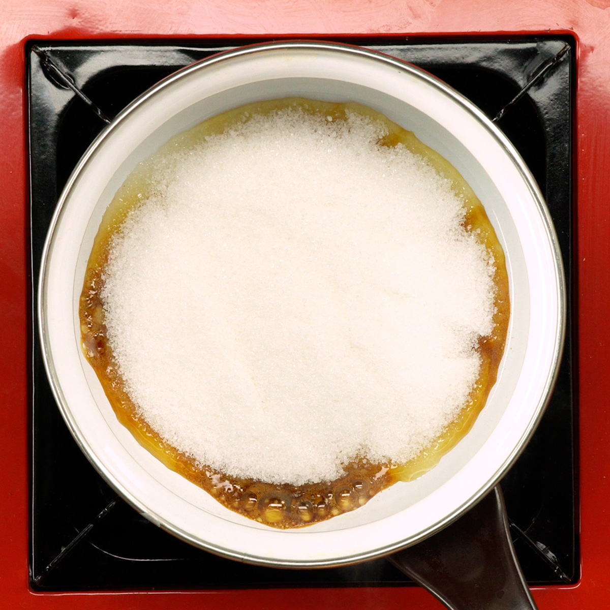 Açúcar sendo caramelizado para a calda do pudim de pão.