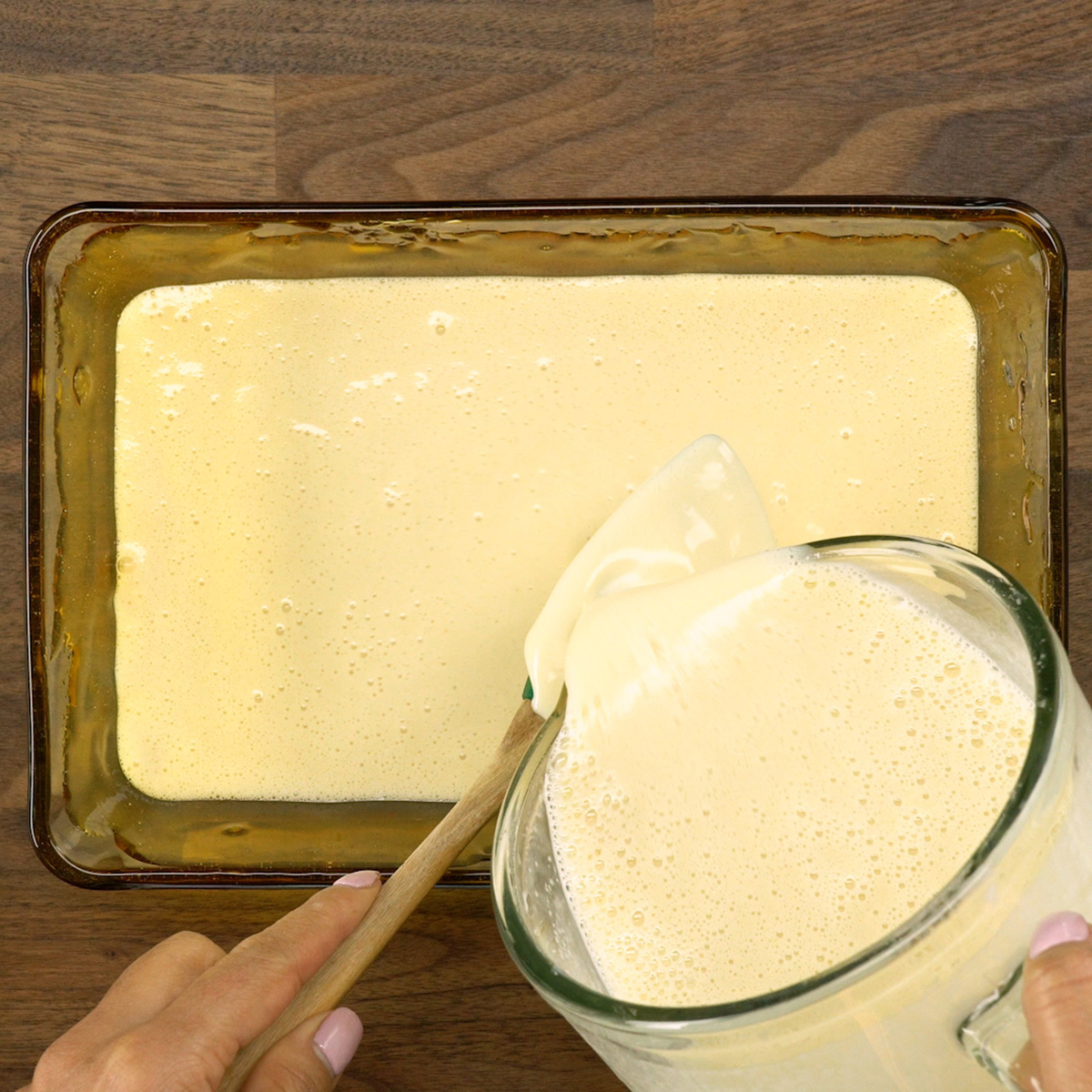 Creme de pudim de pão sendo colocado na forma caramelizada.