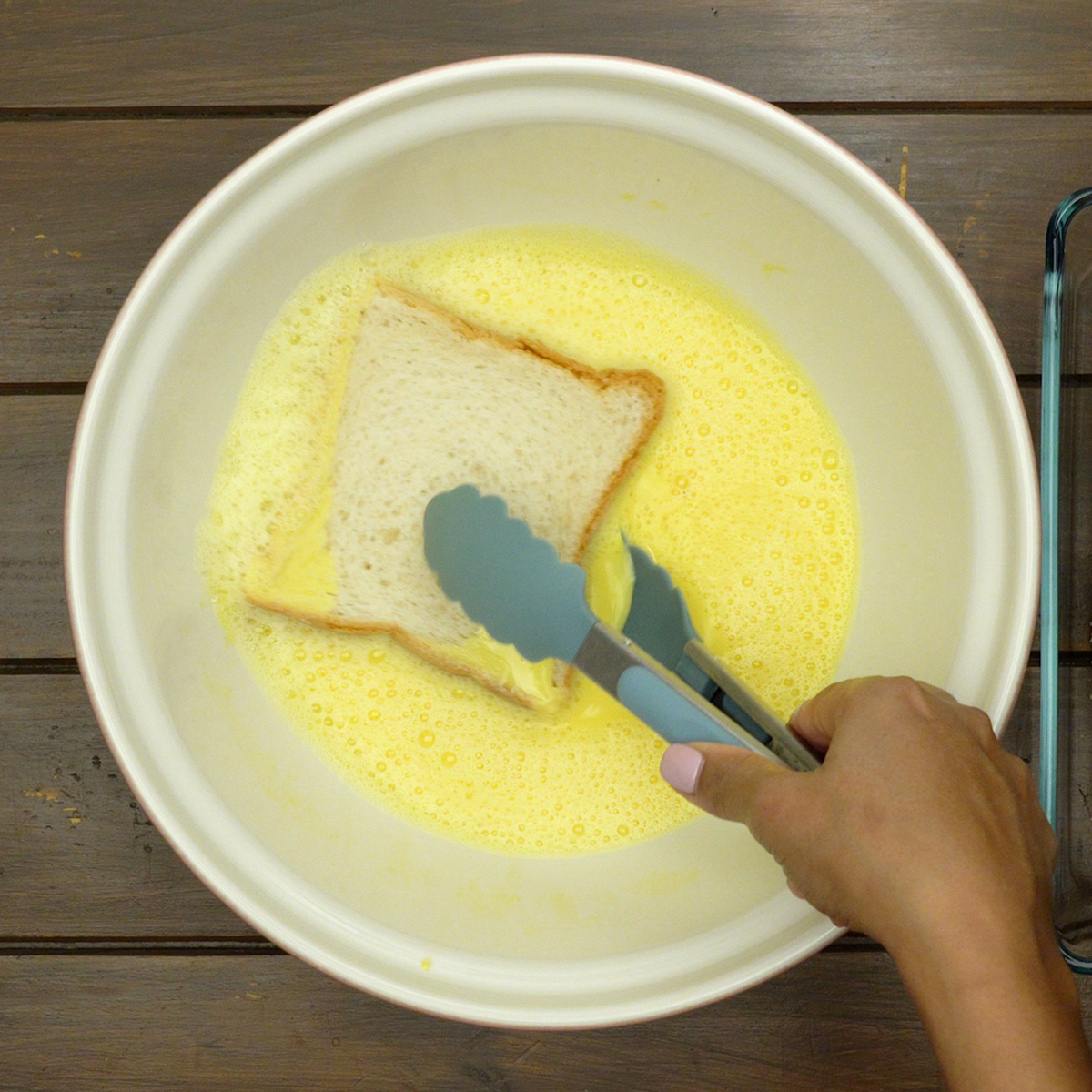 Fatia de pão absorvendo o creme aromatizado para rabanadas de Natal.