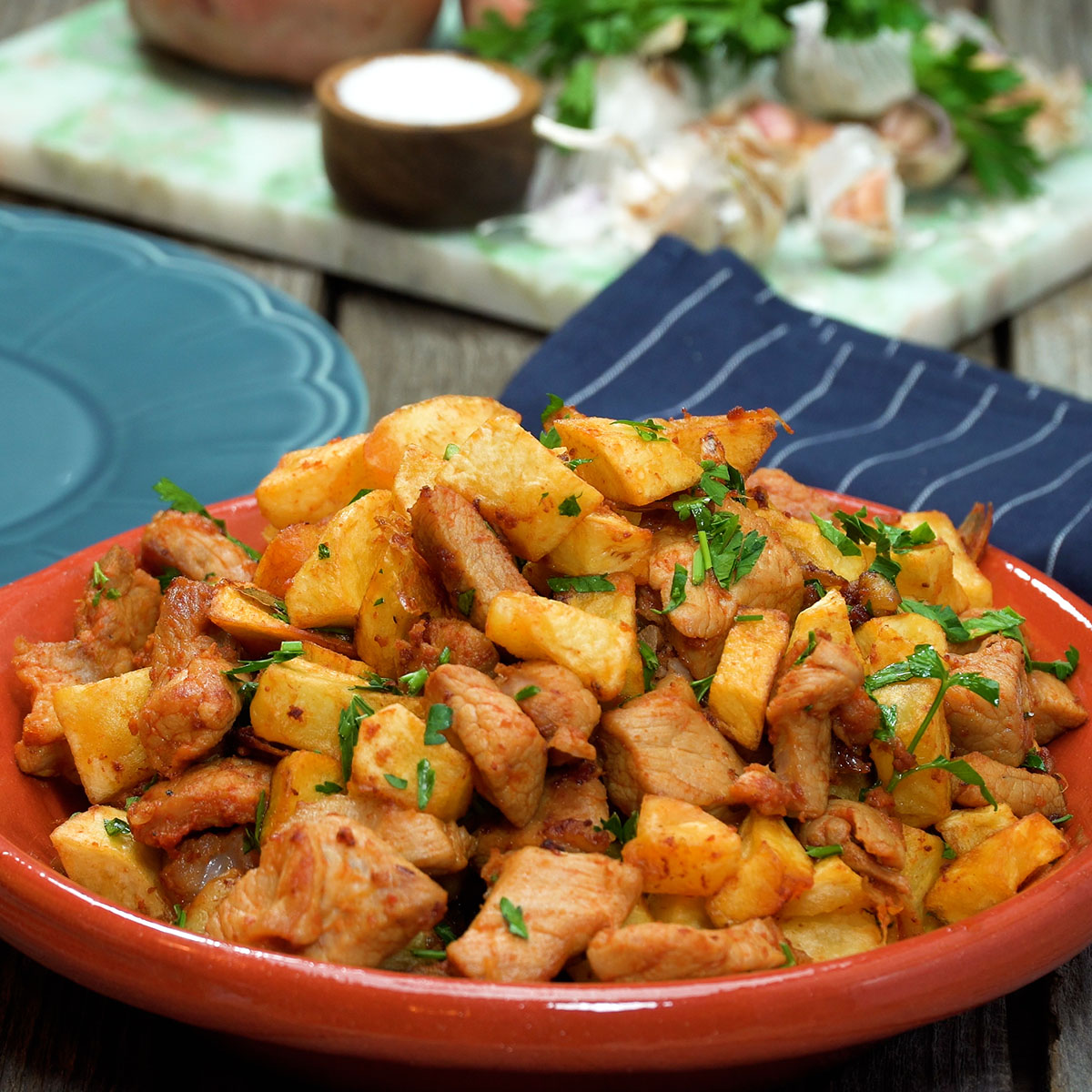 Rojões à portuguesa finalizados com salsa fresca e prontos para servir.