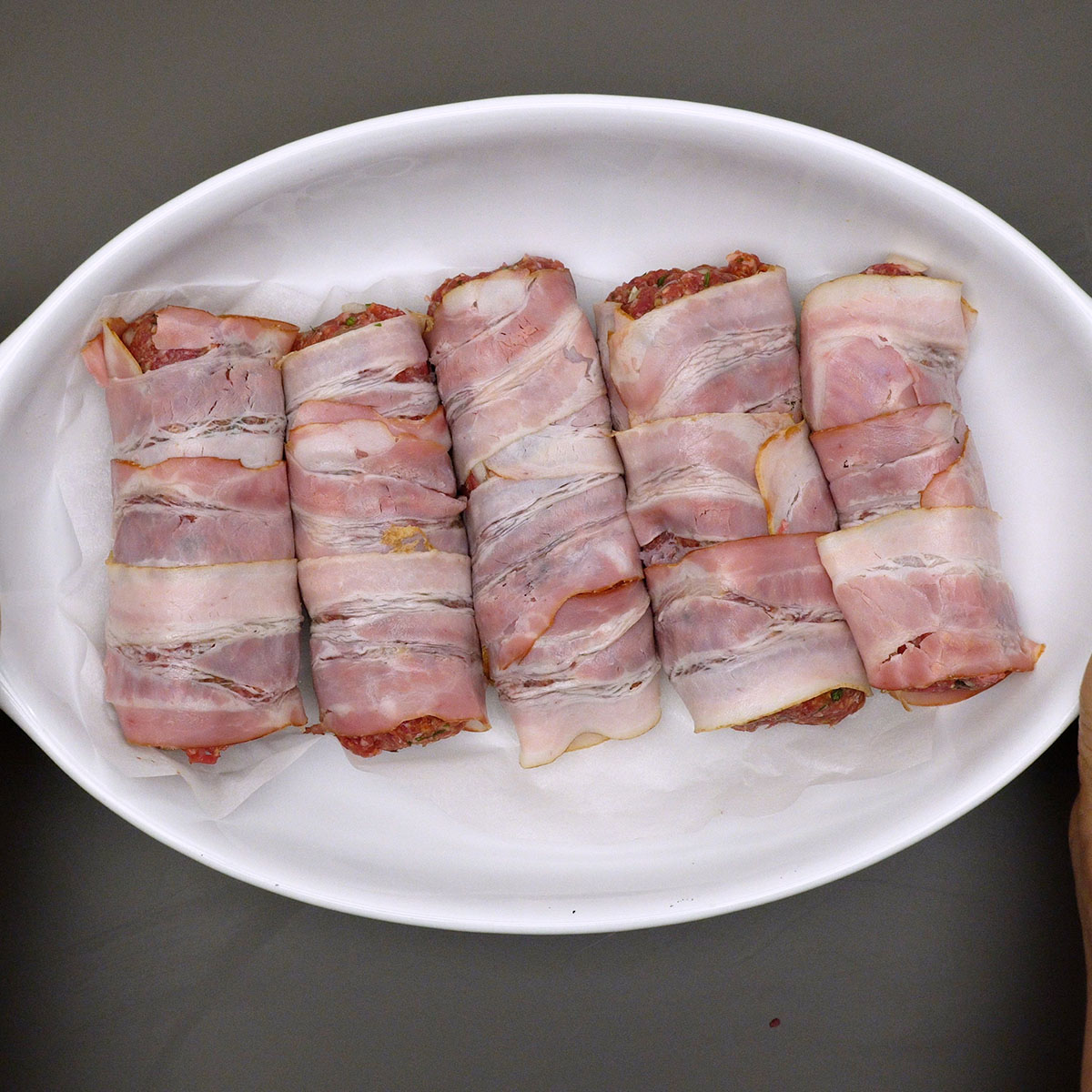Rojões de carne moída assados, dourados e com bacon crocante.