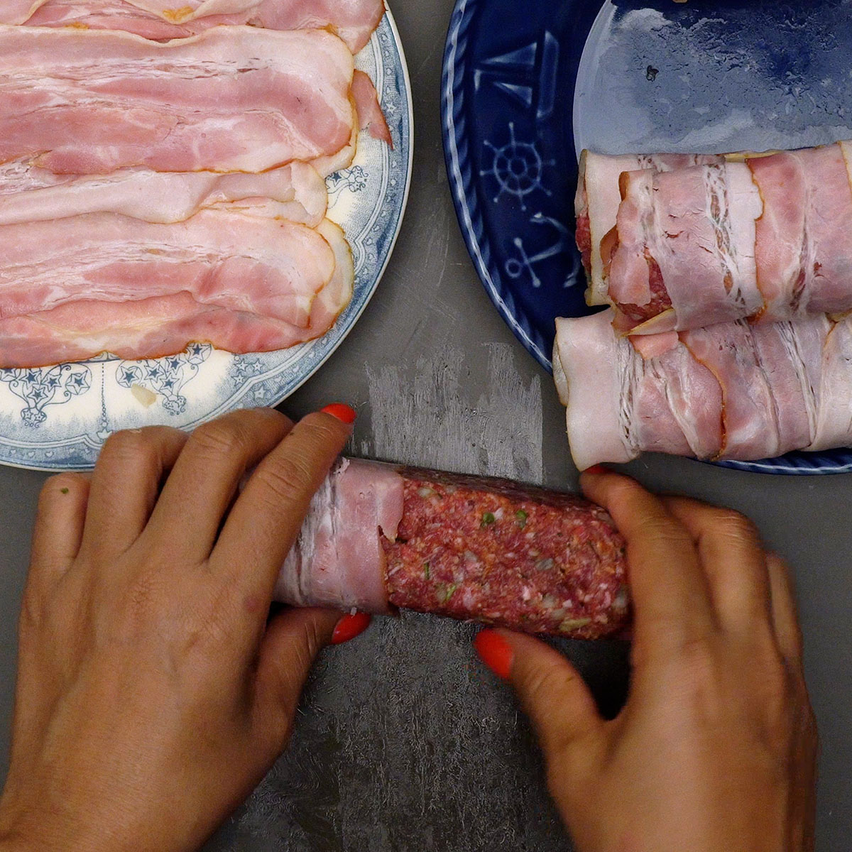 Rojões de carne moída recheados sendo envolvidos com tiras de bacon.