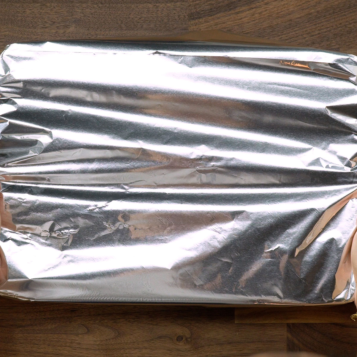Rolo de carne moída recheado assando no forno coberto com papel-alumínio.