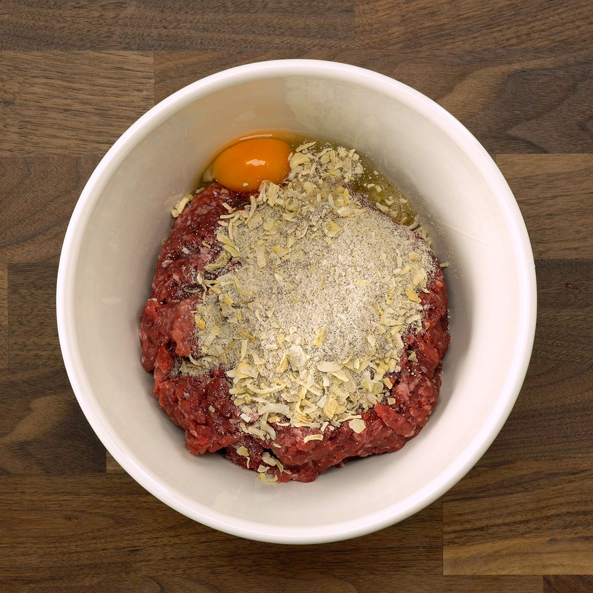 Carne moída temperada e misturada para preparar o rolo de carne recheado.
