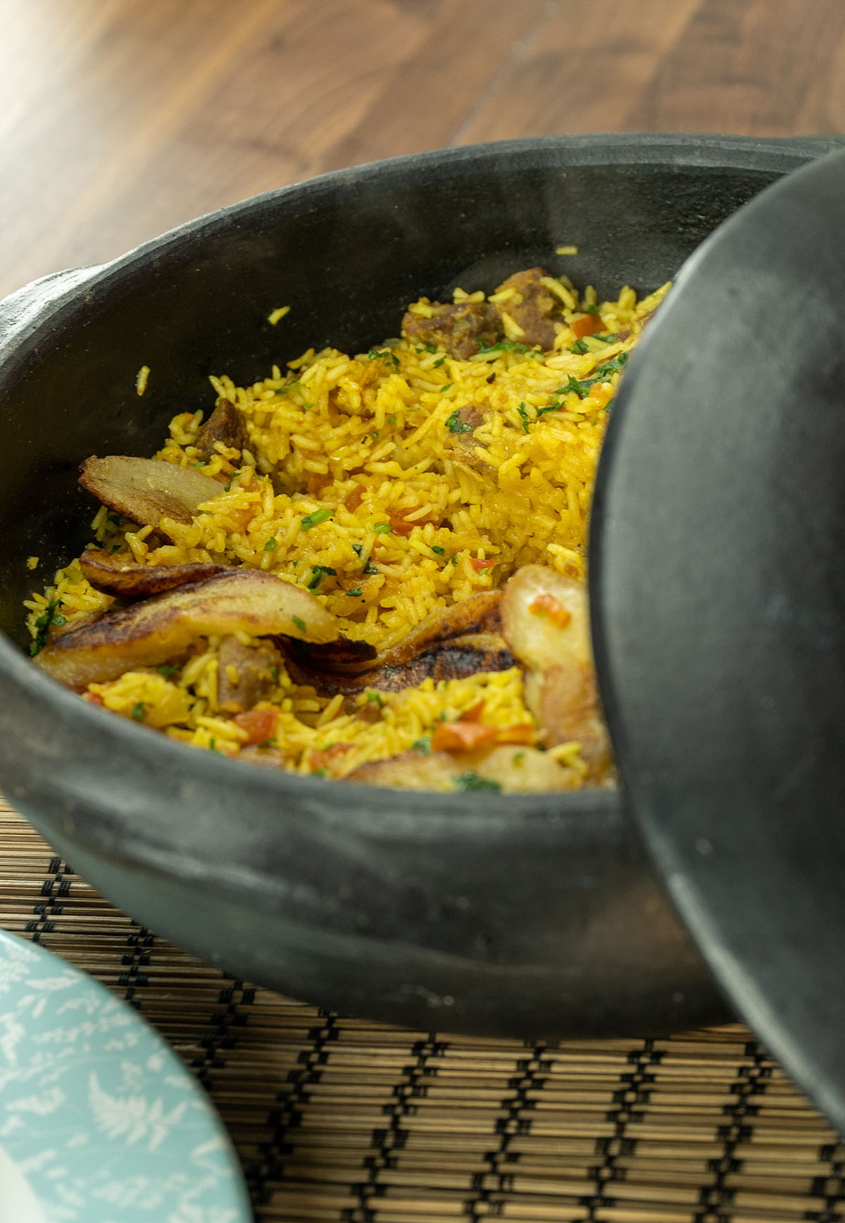 Tacho com arroz de porco com banana frita pronto para ser servido.