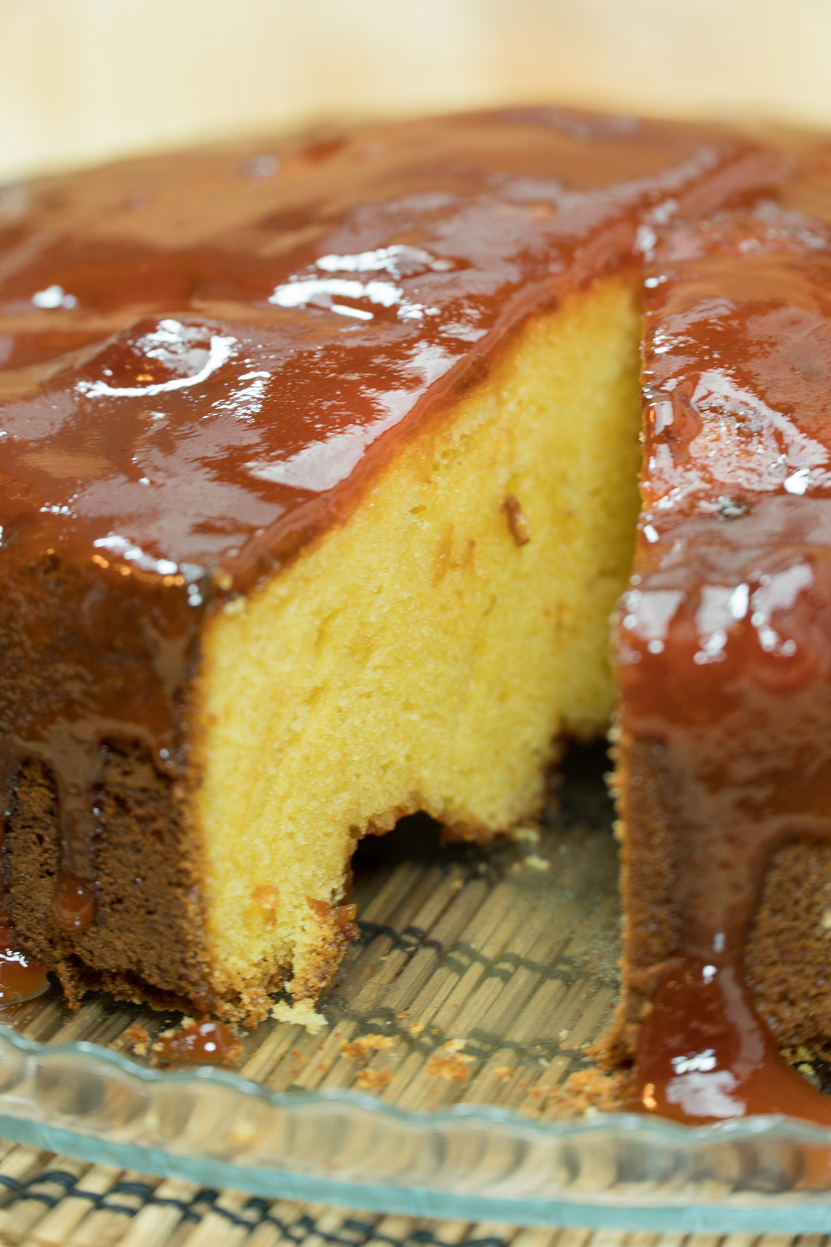 Bolo de fubá com goiabada finalizado com calda de goiabada sendo servida.