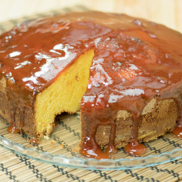 Bolo de fubá com goiabada finalizado com calda de goiabada sendo servida.