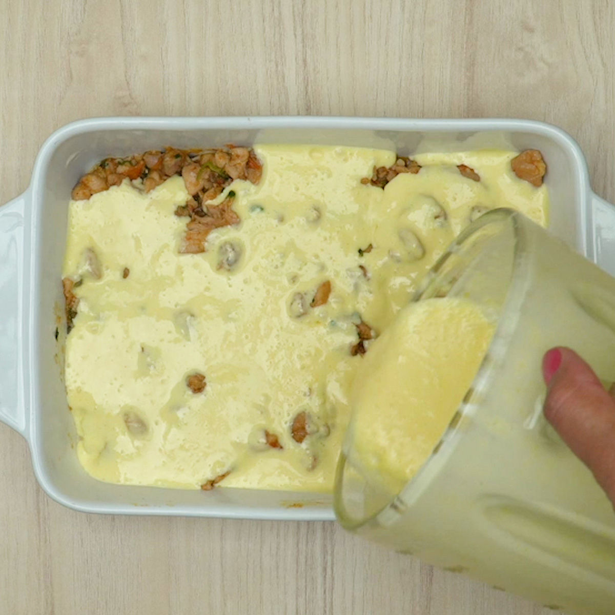 Frango coberto com creme de milho cremoso na travessa.